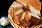 Angel food cake on a wooden serving plate, sliced up