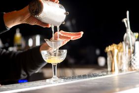 A bartender preparing a cocktail.