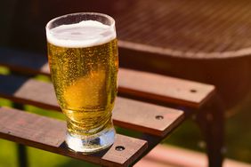 A beer glass rests on a grill