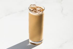 Colorado Bulldog cocktail in a highball glass with ice against a white background.