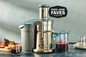 A Breville Fountain Elite Juicer on a countertop with juice, as well as glasses, beets and ginger.