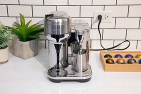 The Breville Nespresso Vertuo Creatista Espresso Machine on a counter near box of coffee pods