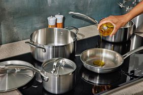 a hand pouring oil into the Tramontina 12-Piece Tri-Ply Clad Stainless Steel Cookware Set sauce pan