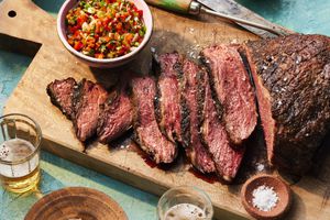 Grilled picanha with Piri Piri on a wooden board with finishing salt and beers