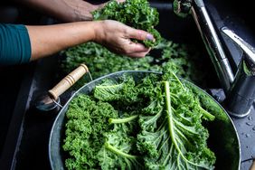 A person washing kale.