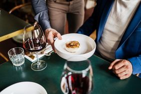 A server placing food in front of a customer. 