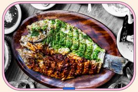 A flat grilled fish on a wooden plate