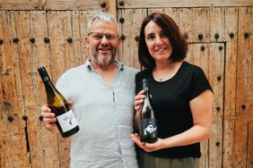 Portrait of Joan and Angels Rubio holding bottles of wine