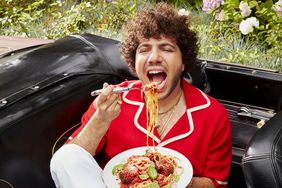 Benny Blanco eating pasta in a car.